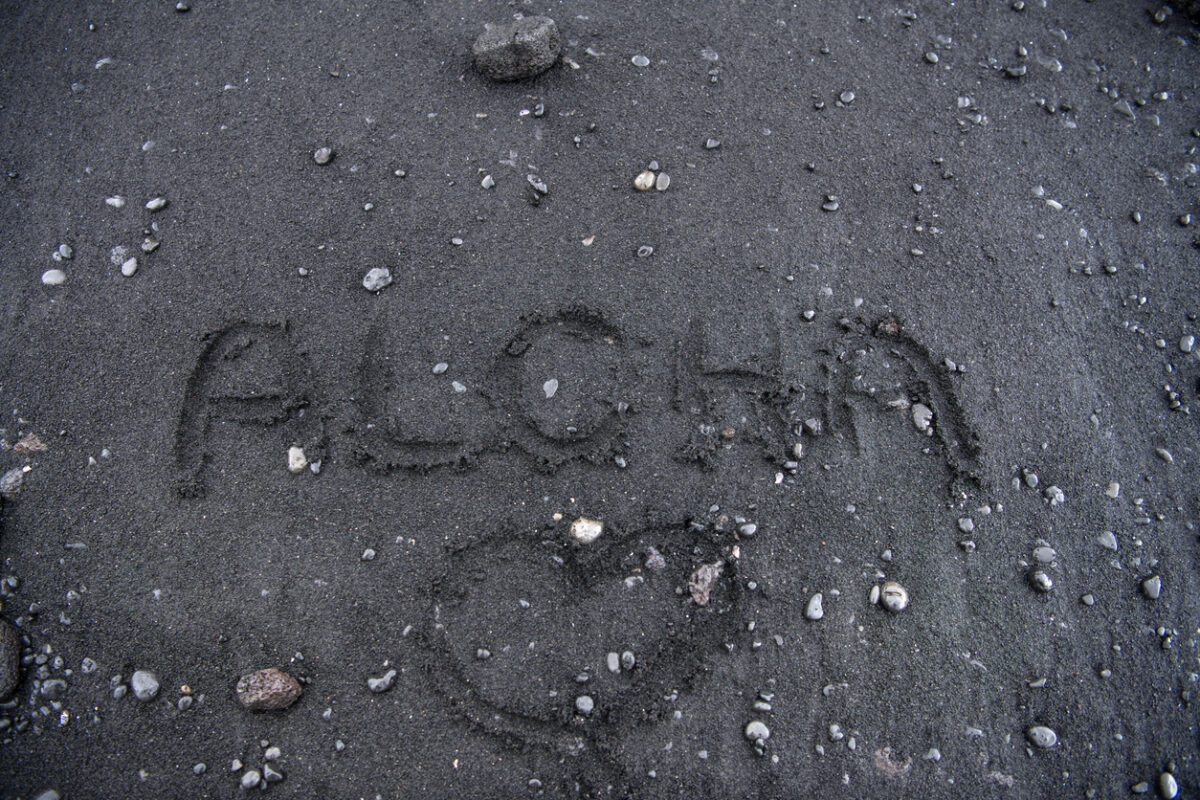 aloha written in the black sand of hawaii