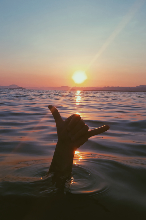 shaku hand gesture in hawaiin ocean