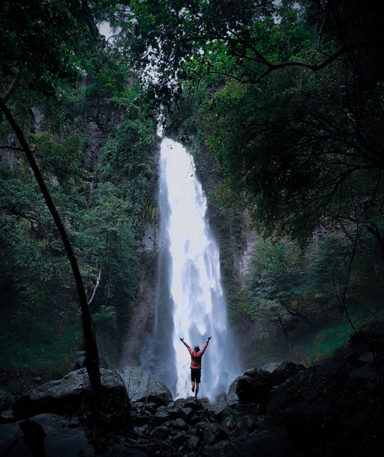 man under waterfall