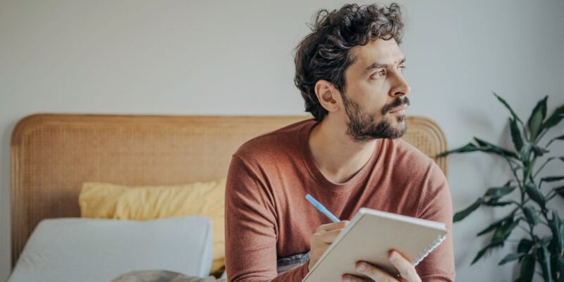 man practicing mindfulness through journaling when he gets up in the morning