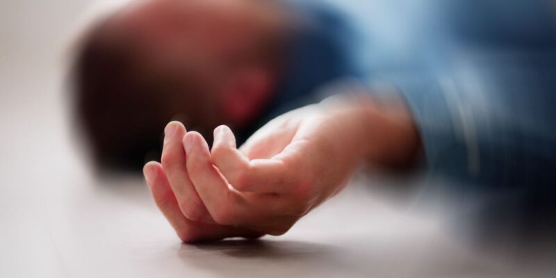 man lying unconscious on the floor possibly from a drug overdose