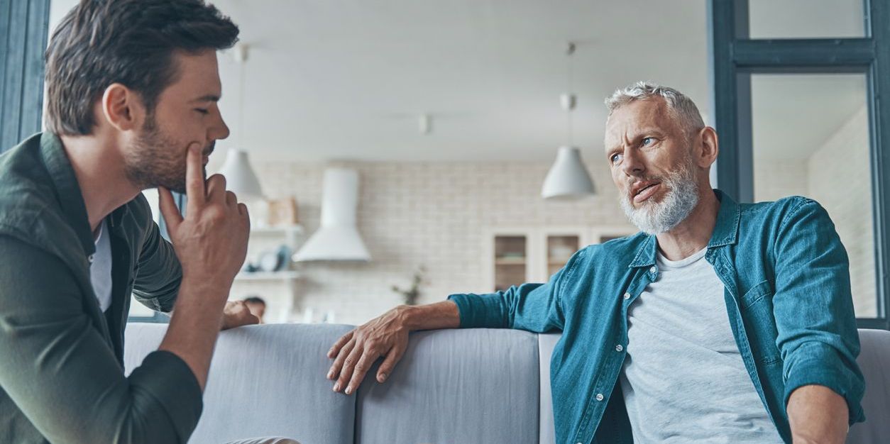 father talking to adult son in serious discussion